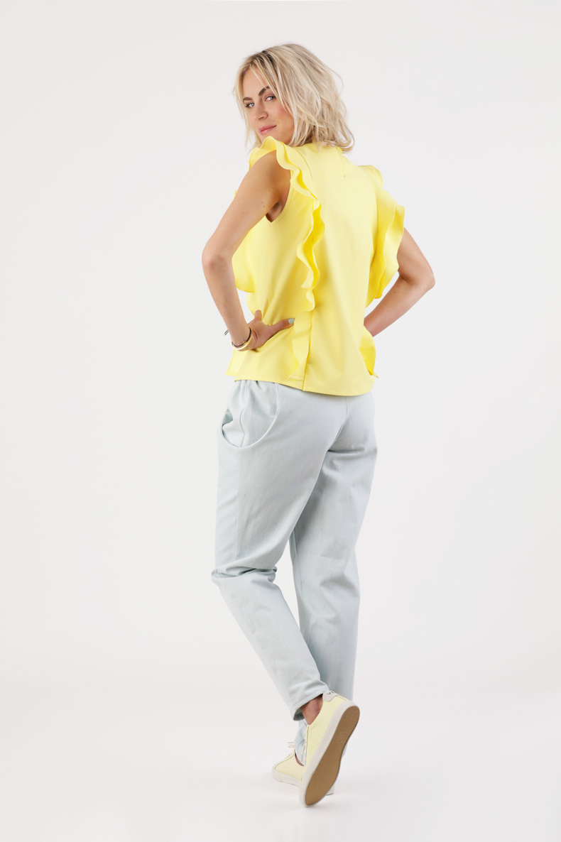 The back view of a woman wearing a yellow top.