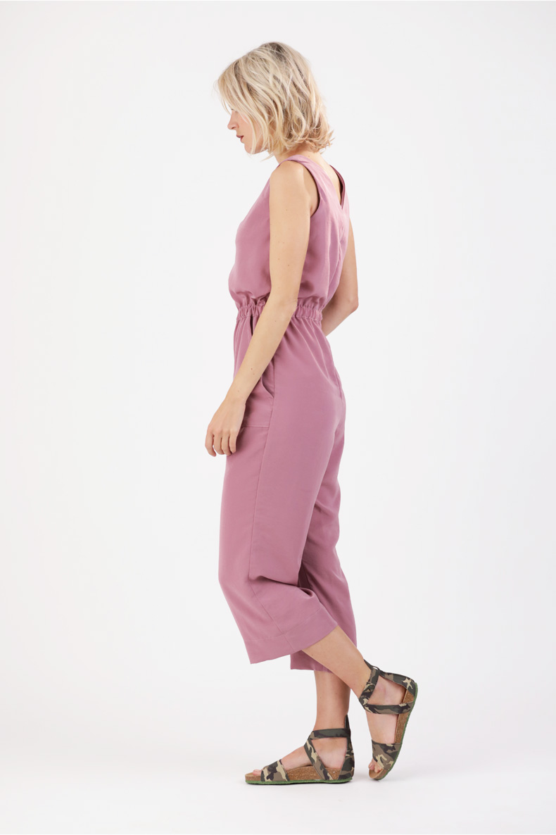 The back view of a woman wearing a pink jumpsuit.