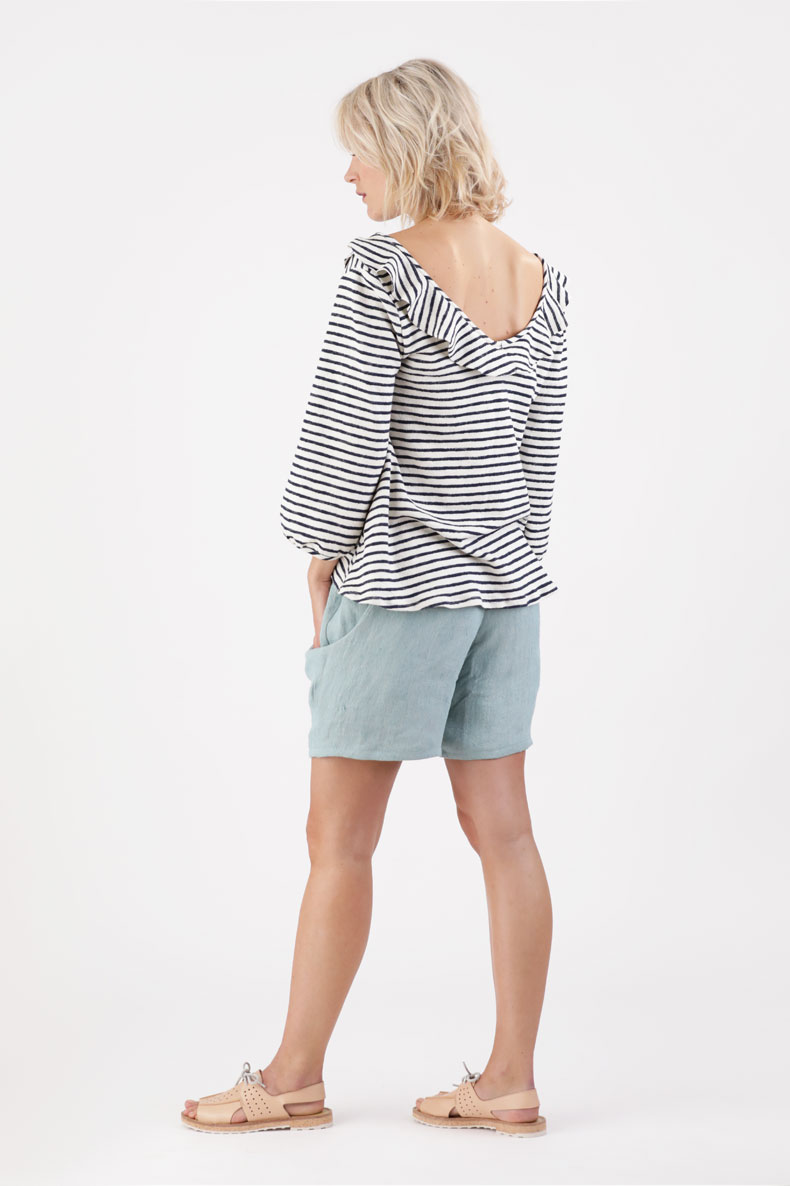 The back view of a woman wearing a striped top and shorts.