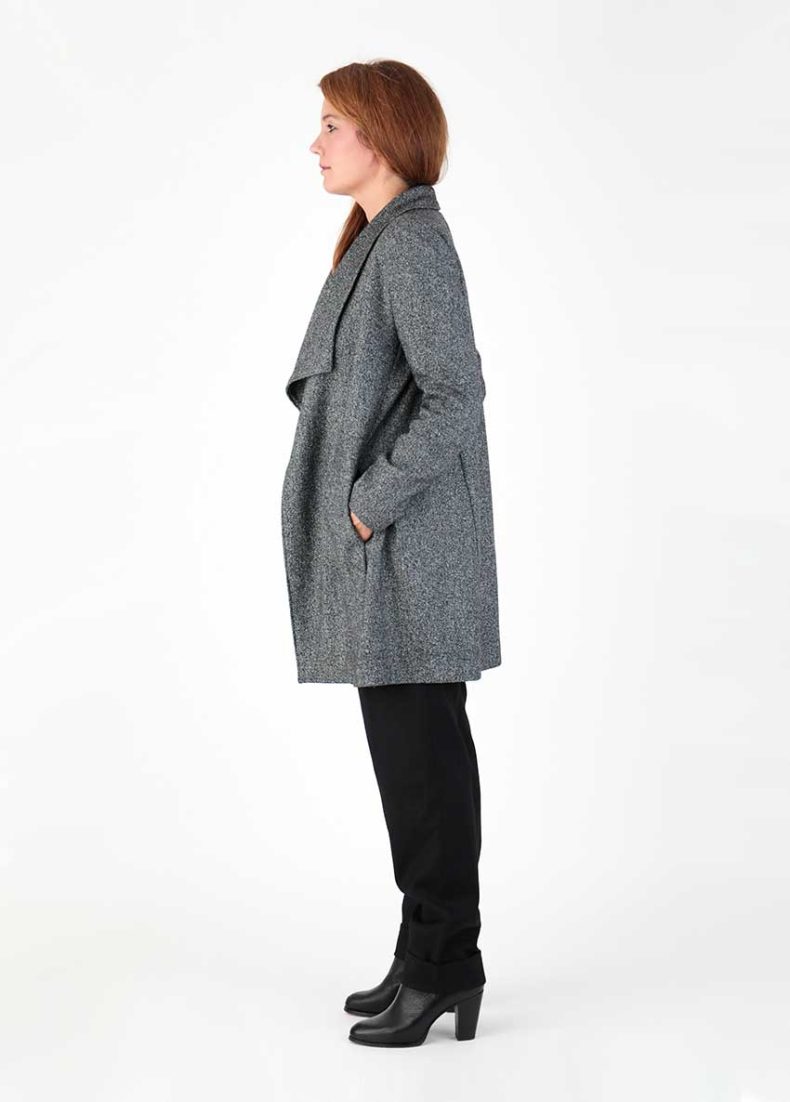A side view of a woman wearing a gray coat.